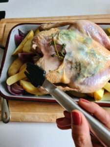 Hähnchen in Ofenform wird mit Pinsel bestrichen