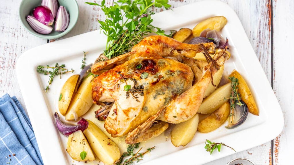 Ganzes Hähnchen im Backofen mit Kartoffeln auf Servierplatte