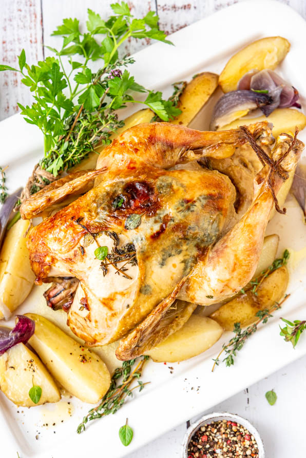 Ganzes Hähnchen im Backofen mit Kartoffeln auf Servierplatte