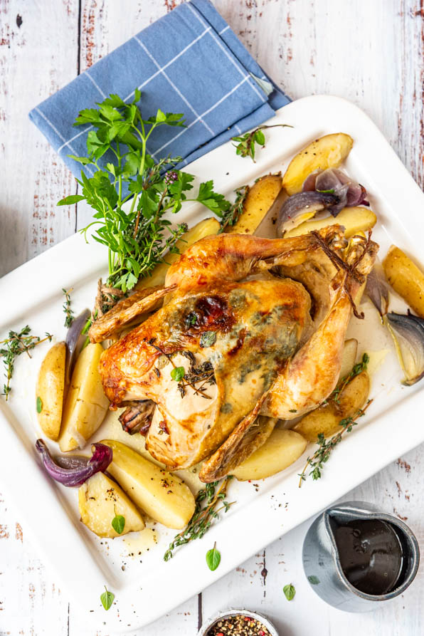 Ganzes Hähnchen im Backofen mit Kartoffeln auf Servierplatte