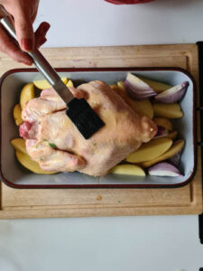 Hähnchen in Ofenform wird bestrichen