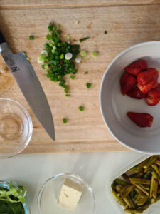 Lauchzwiebel wird auf Holzbrett geschnitten