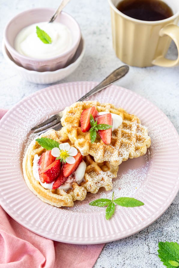 Zwei Stück belgische Waffeln auf Teller mit Kaffee