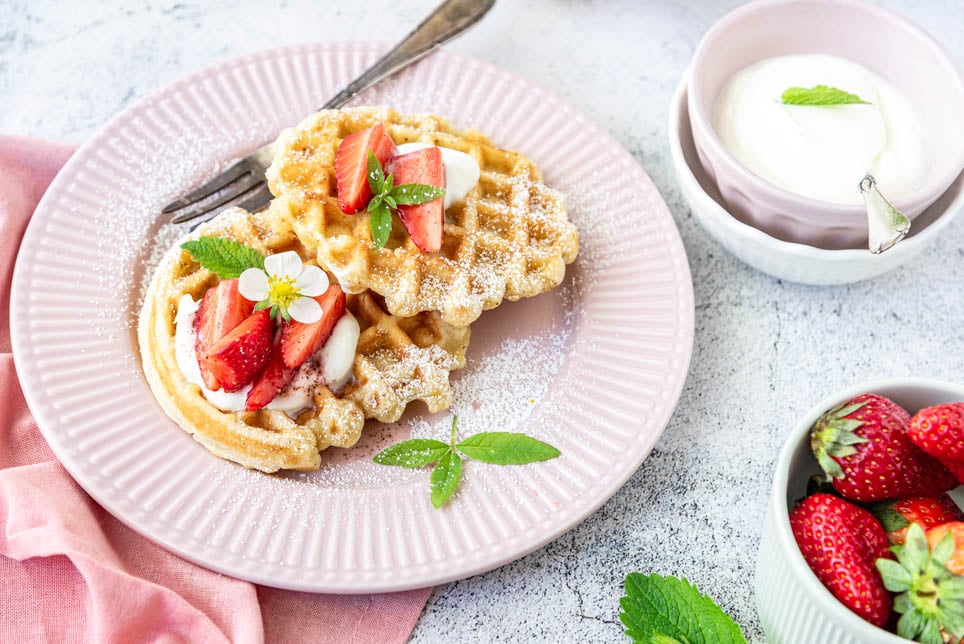 Zwei Stück belgische Waffeln auf Teller mit Kaffee