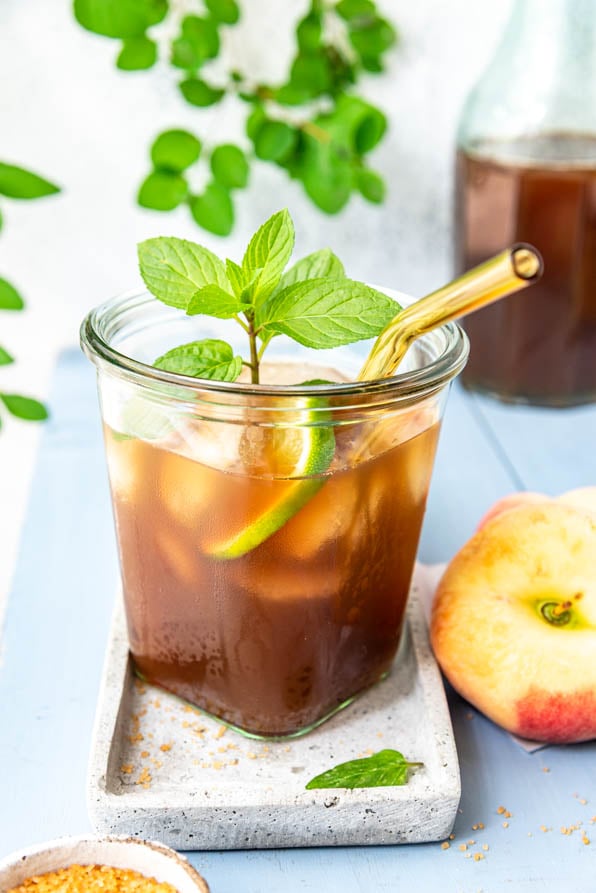 Ein Glas hausgemachter Eistee Pfirsich auf einem Tablett