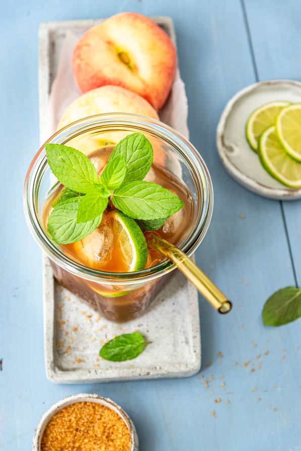 Ein Glas hausgemachter Eistee Pfirsich auf einem Tablett