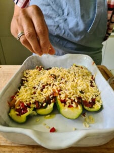 Gefüllte Zucchini werden mit Käse bestreut