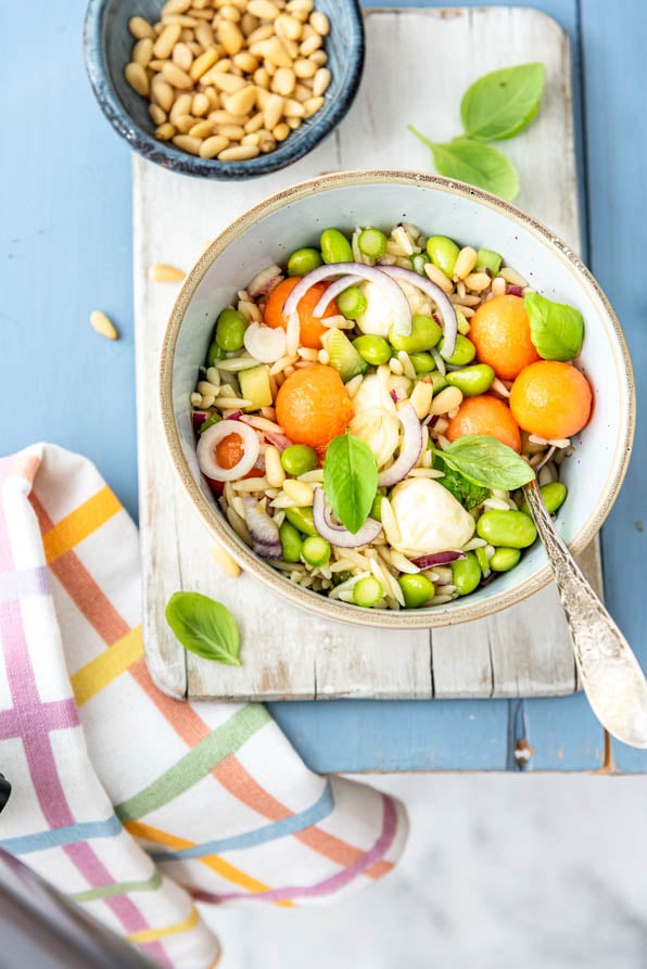 fruchtiger Kritharaki Nudelsalat auf Holzbrett