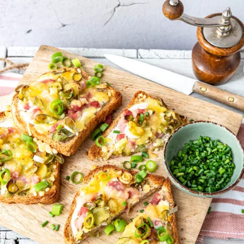Mehrere Scheiben Flammkuchen Toast auf einem Brett angerichtet