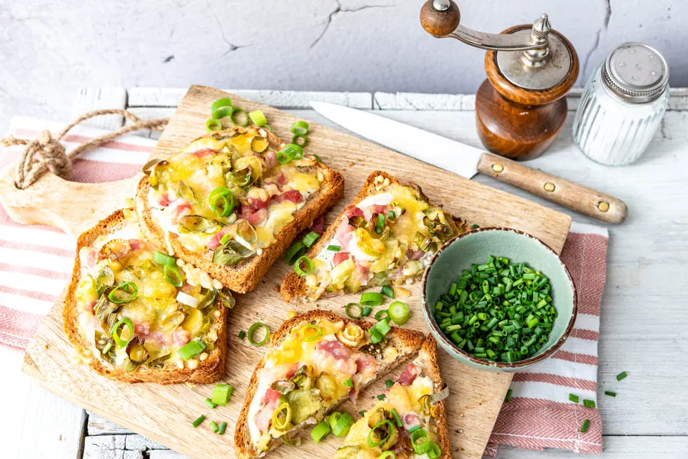 Mehrere Scheiben Flammkuchen Toast auf einem Brett angerichtet