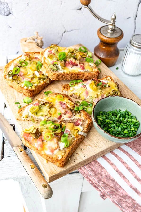 Frisch zubereitete Flammkuchen Toast Stücke liegen auf Holzbrett