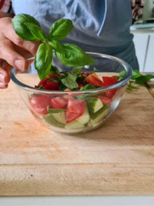 frischer Basilikum wird zu italienischem Brotsalat gegeben