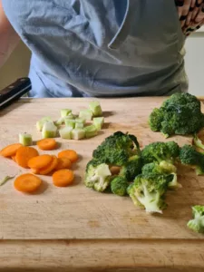 Gemüse für Kichererbsen Curry wird auf Holzbrett geschnitten