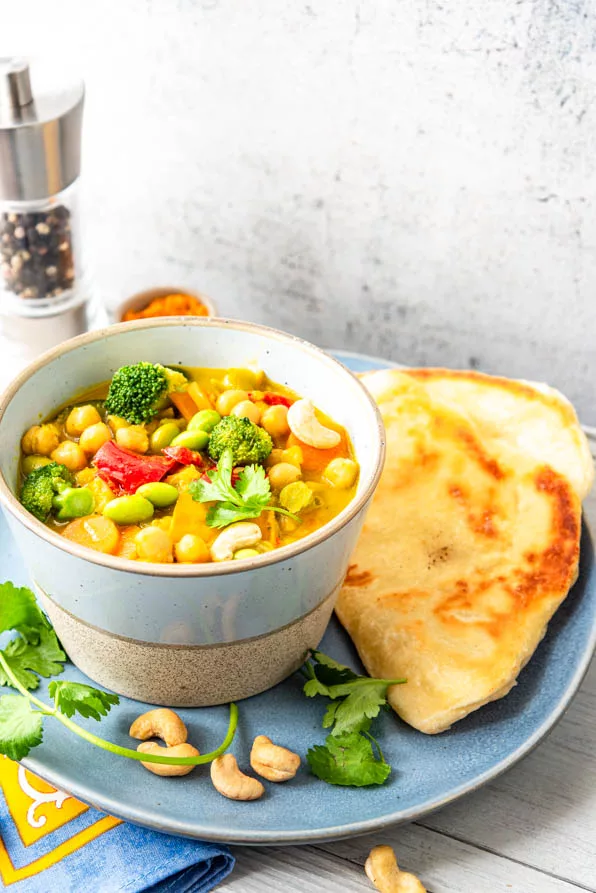 Frisch gekochtes Kichererbsen-Curry auf Teller mit Naan-Brot