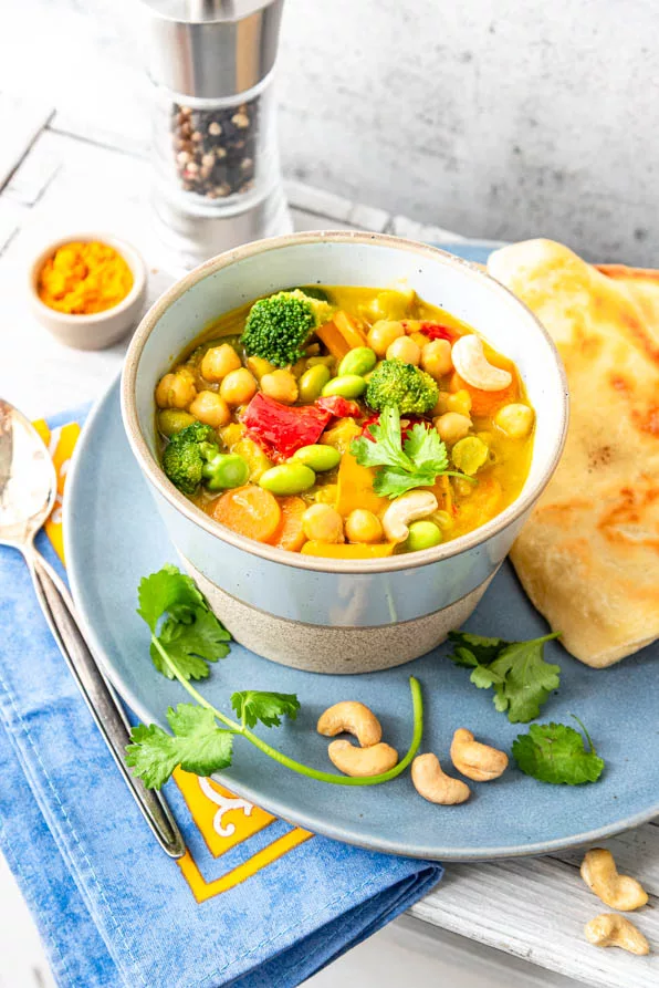 Vegetarisches Curry mit Kichererbsen auf Teller mit Naan Brot