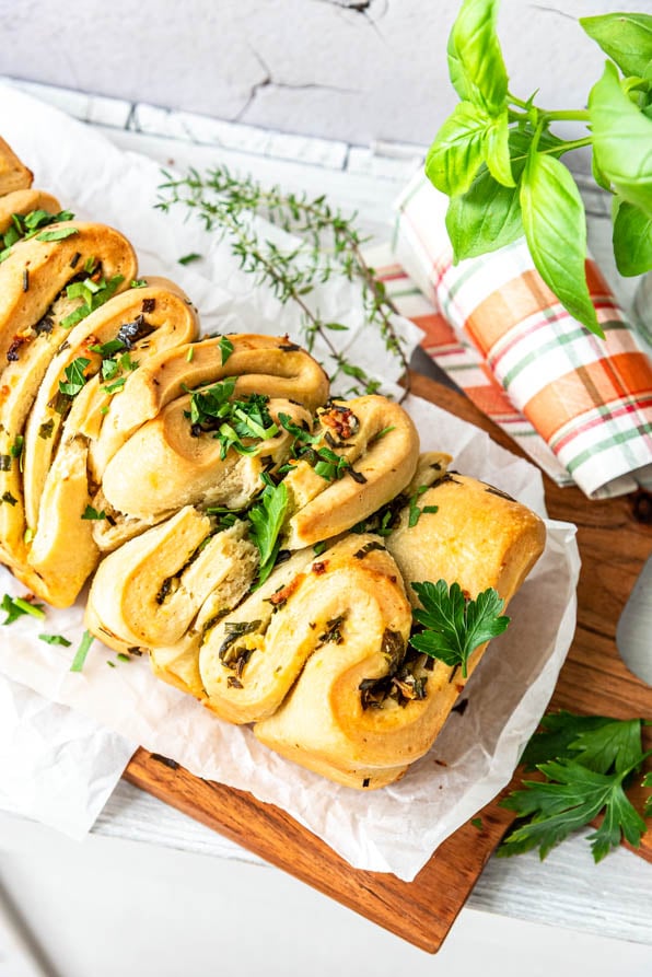 Fächerbrot mit Kräutern auf einem Holzbrett
