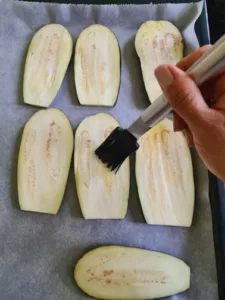 Auberginenscheiben für Parmigiana di Melanzane auf Backblech mit Öl