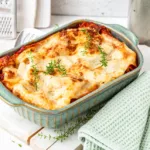 herbstliche Kürbislasagne in Auflaufform auf Holzbrett