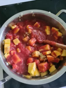 Kürbisstücke und Tomatensauce in Kochtopf