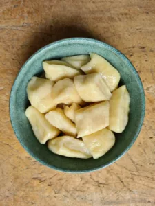Eine Schüssel selbstgemachte Gnocchi auf rustikalem Holzbrett
