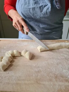 Beim Gnocchi selber machen: Gnocchi werden von Rolle geschnitten