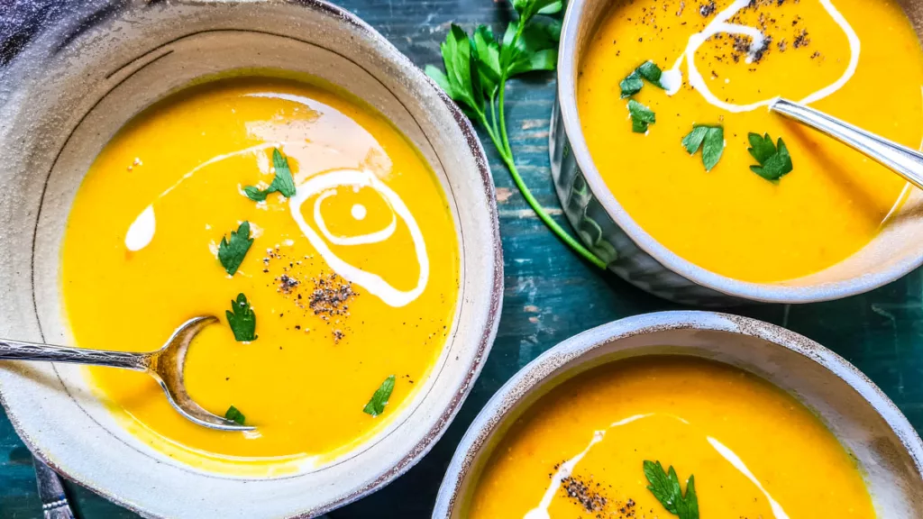 3 Schälchen Kürbissuppe mit Kokosmilch und Petersilie