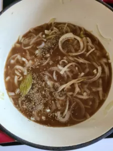 Die Zwiebel-Mehl-Mischung wird mit Brühe aufgefüllt