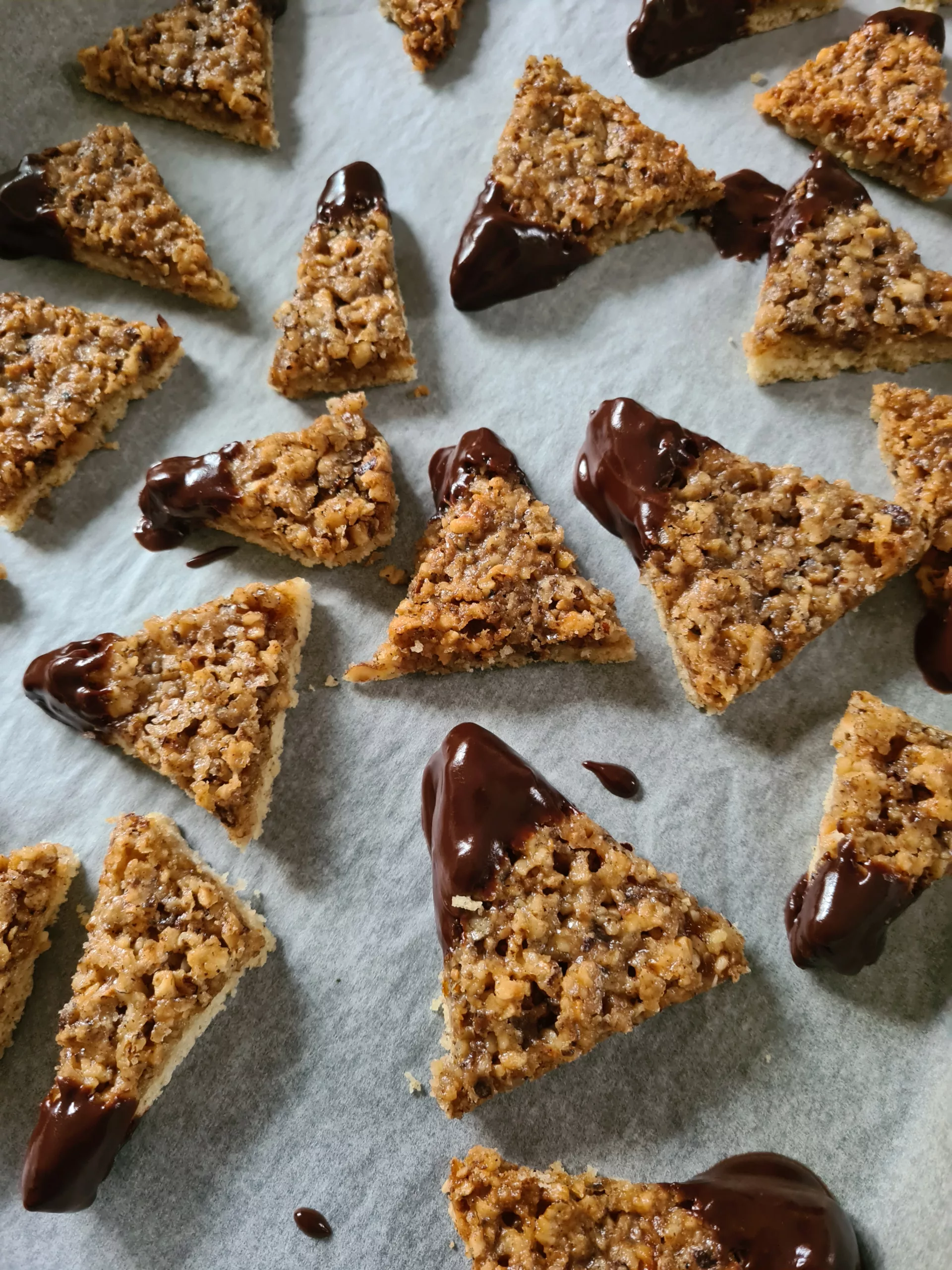 frisch in Schokolade getauchte Nussecken auf Backpapier