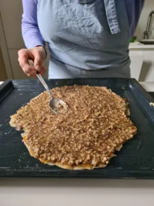 Walnuss-Haselnuss-Masse wird auf den Teig gegeben und glatt gestrichen