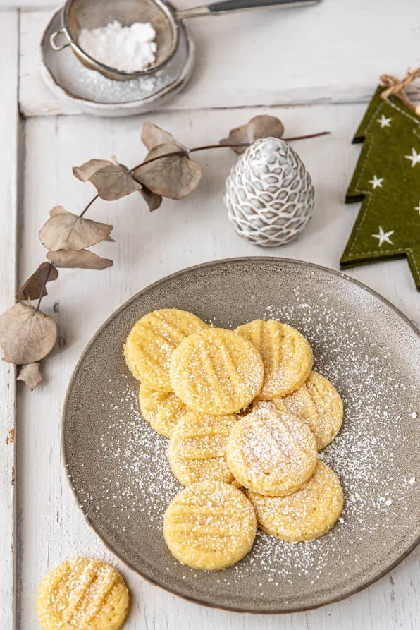 Teller mit Puddingplätzchen und Tannenzapfen als Deko