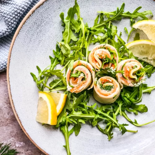 Pfannkuchen Lachsrolle mit Frischkäse und Dill auf hellem Teller