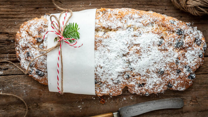 quarkstollen-rezept Weihnachtsstollen ohne Hefe mit Rosinen und Mandeln auf Holzuntergrund