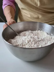 Mehl, Backpulver und Gewürze in einer Schüssel für den Quarkstollen mischen