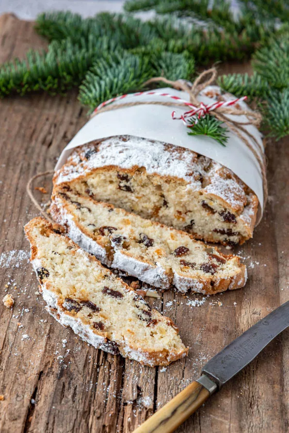 Quarkstollen mit Rosinen in Scheiben geschnitten auf rustikalem Holzbrett
