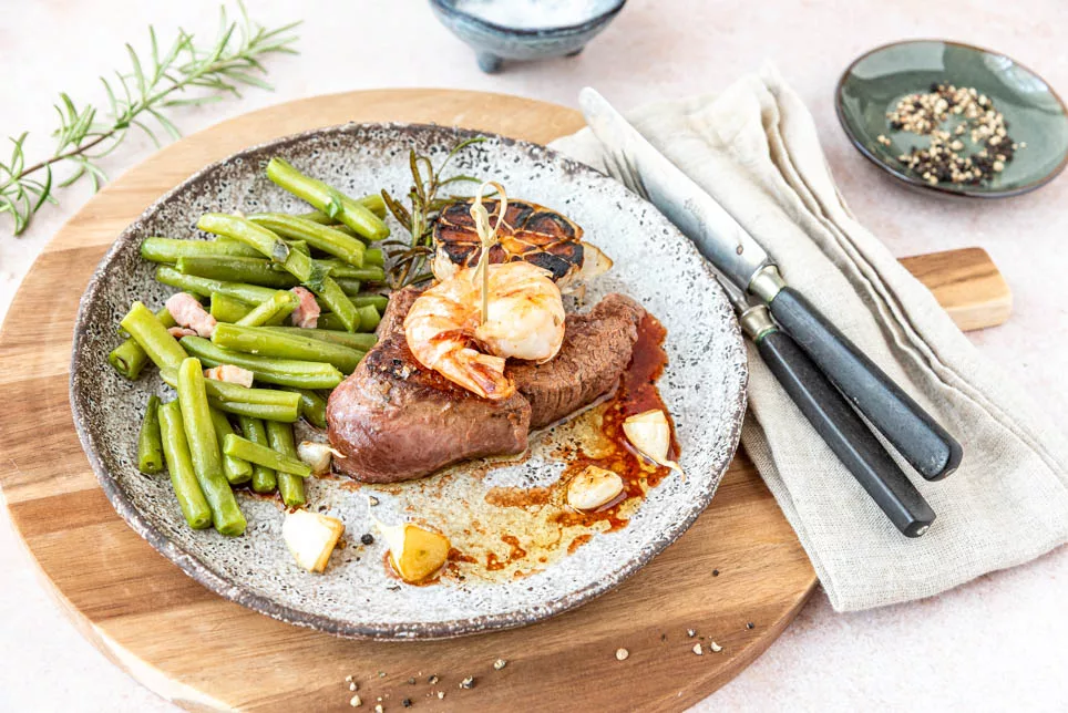 Festlich angerichtetes Steak mit Garnele und Kräutern