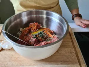 Hackfleisch für die Krautwickel wird mit den übrigen Zutaten vermischt