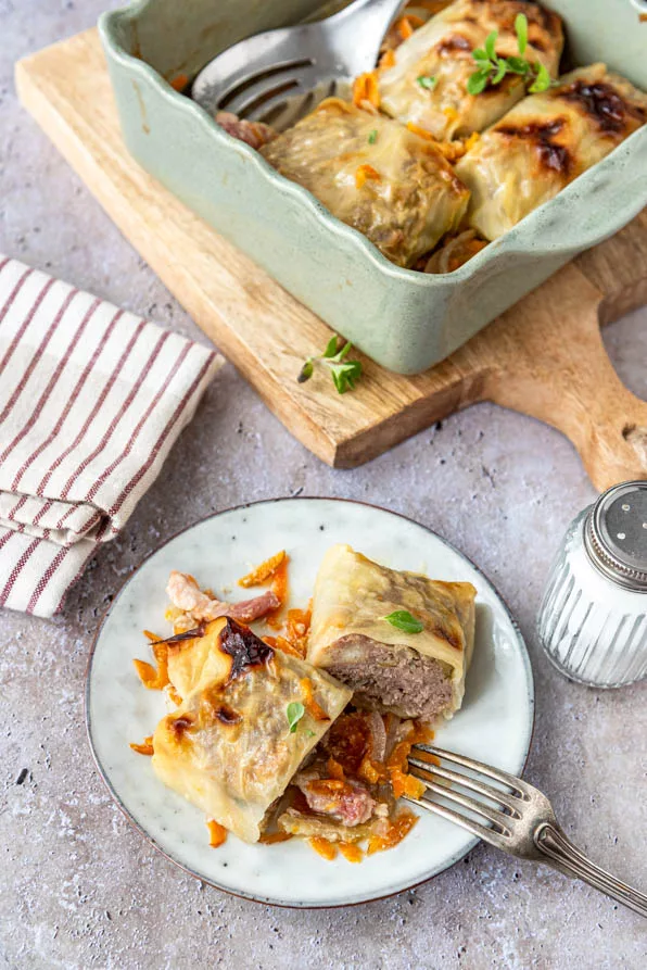 Angeschnittene Kohlroulade mit saftiger Hackfleischfüllung, serviert auf einem Teller mit würziger Sauce