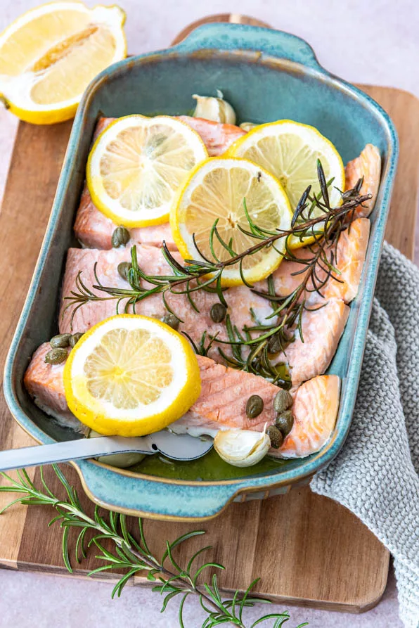 Lachsfilets im Ofen gegart, belegt mit Zitronenscheiben und frischen Kräutern