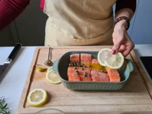 Lachsfilets in einer Auflaufform mit Zitronenscheiben, Kapern und Olivenöl