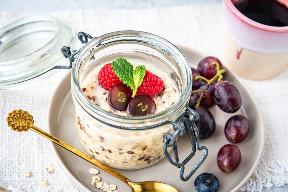 Overnight Oats im Glas mit Beeren und Trauben als gesundes Meal Prep Frühstück