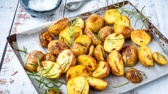 rosmarinkartoffeln-ofen Rosmarinkartoffeln aus dem Ofen goldbraun gebacken auf einem Blech mit frischem Rosmarin und grobem Salz