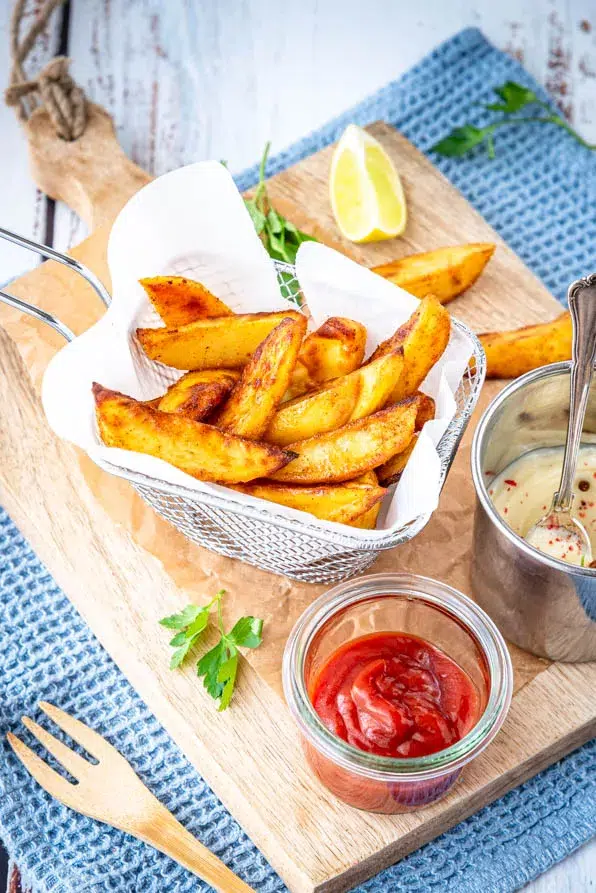 Kartoffelspalten serviert mit Ketchup und Dip
