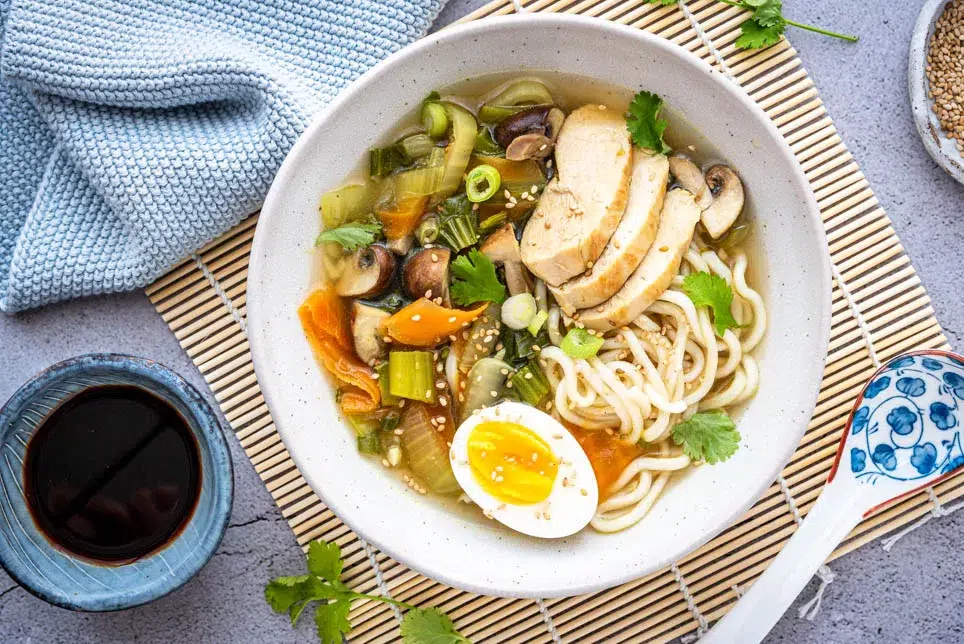 Japanische Ramen Suppe mit Hähnchen, Ramen-Nudeln, Pilzen und weich gekochtem Ei