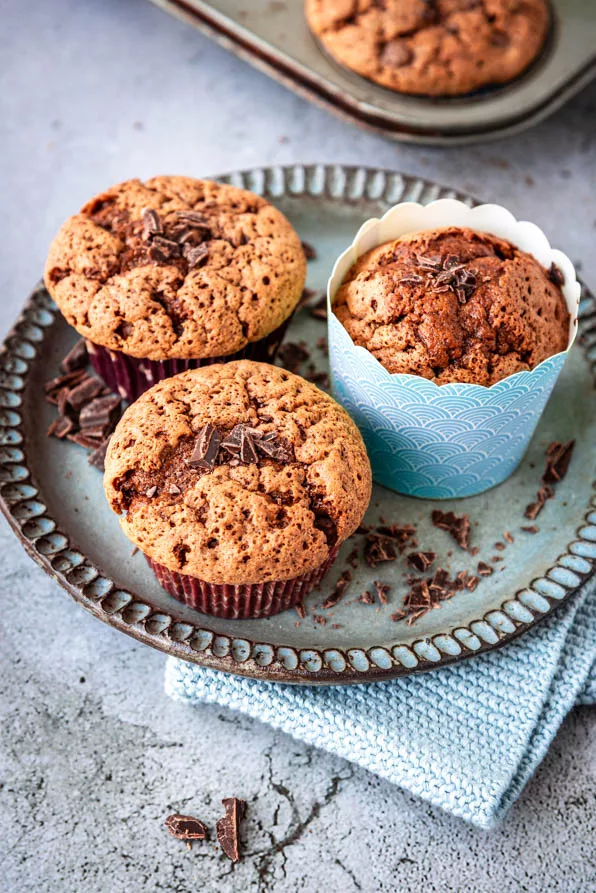 Schokomuffins Rezept – drei frisch gebackene Muffins mit Schokostückchen auf Teller